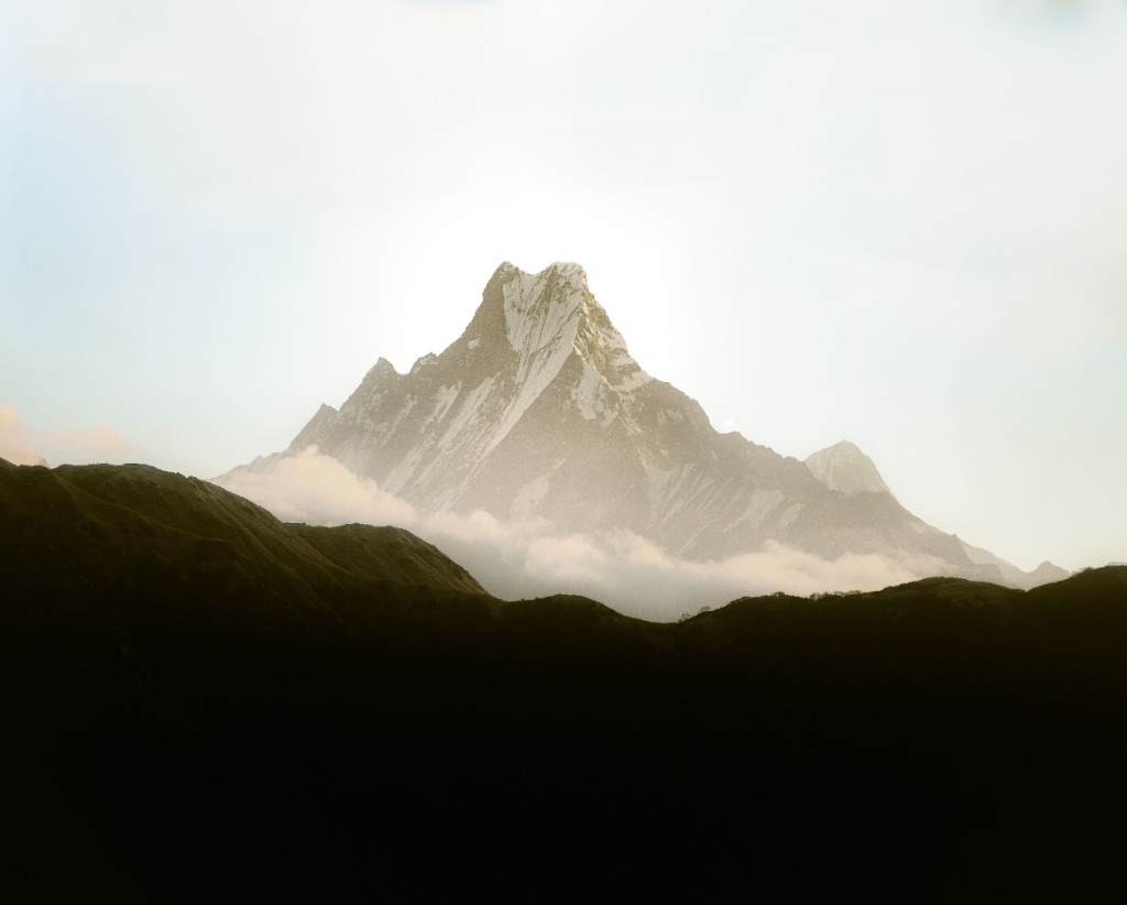 Vetta innevata sopra le nubi, all'alba