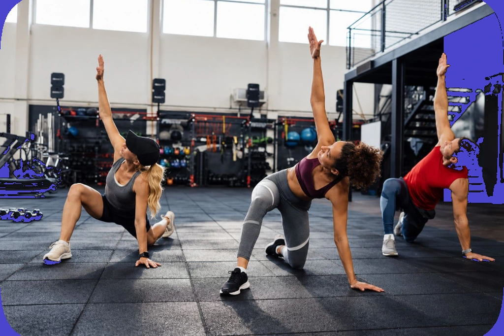 Tre atleti in affondo con torsione durante una classe di functional training