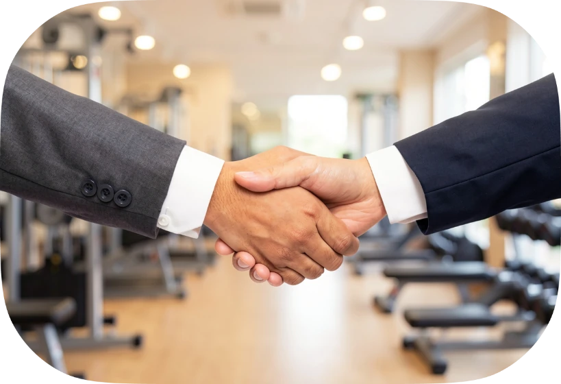 Handschlag auf der Trainingsfläche zwischen dem Inhaber eines Fitnessstudios und einem Berater
