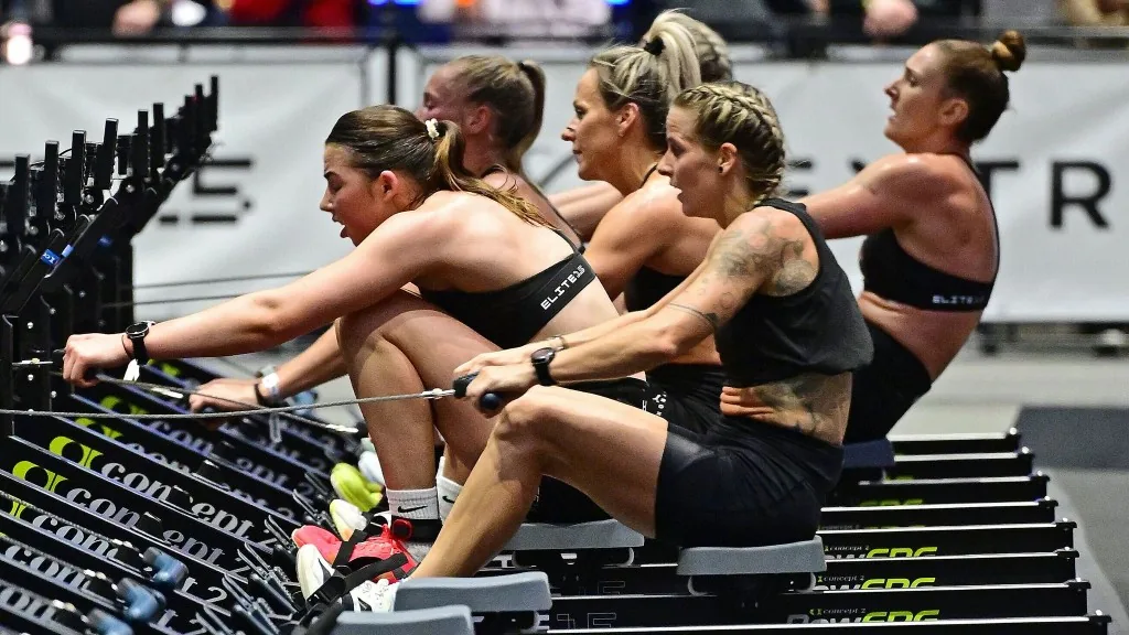 Atlete in gara su vogatori Concept2 durante una prova HYROX.